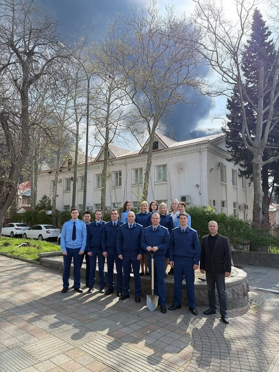 Прокуратура Краснодарского края отчиталась об акции по озеленению в преддверии 9 Мая, опубликовав фотографии сотрудников на фоне столба дыма от затяжного пожара в туапсинском морском терминале после атаки дронов.